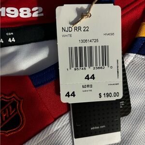 Men’s size Small white and red NJ Devils jersey. NEVER WORN WITH TAGS.